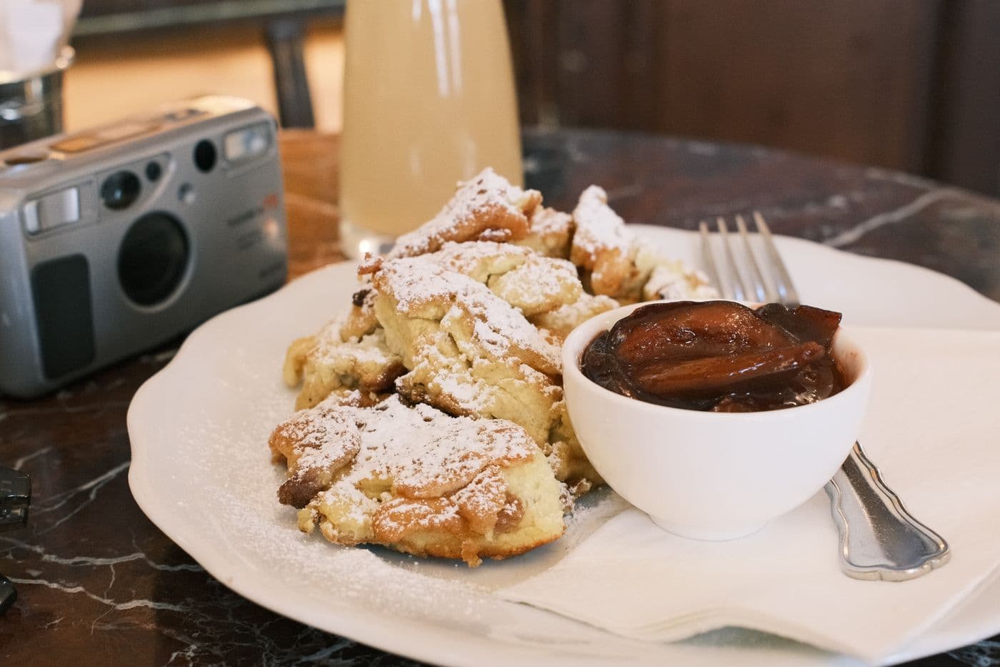 A delicious plate of Kaiserschmarrn with plum compote at a cozy Vienna café.
